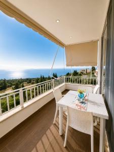 a balcony with a table and chairs and the ocean at DeJon Apartment in Gjilek