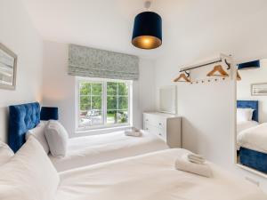 a bedroom with two beds and a window at Cartmel Cottage in Lindale +9 photos