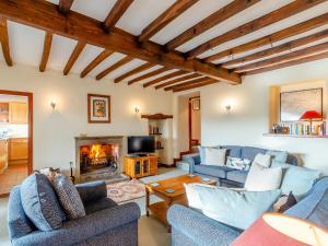 a living room with blue couches and a fireplace at Griff Head Cottage in Carlton