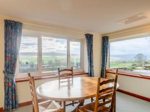 a dining room with a table and chairs and windows at Griff Head Cottage in Carlton +17 photos