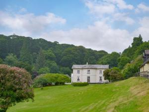 a white house on a hill with a green field at Gibson Apt- Cv11 in Liskeard