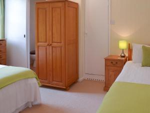 a bedroom with a bed and a wooden cabinet at Gibson Apt- Cv11 in Liskeard