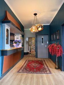 a living room with blue walls and a vase of flowers at West Rocks Hotel in Eastbourne