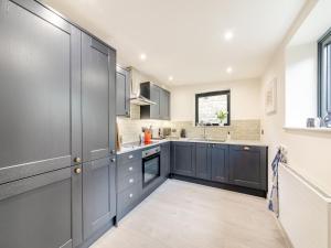 a kitchen with grey cabinets and a window at Number 29 in Alnwick