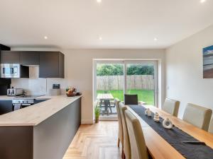 a kitchen and dining room with a table and chairs at The Caddy's Lodge - Uk47762 in Bamburgh