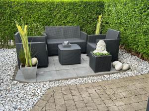 a patio with chairs and plants in a garden at La Vie est Belle chambre d hôte in Verviers