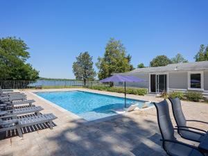 a swimming pool with chairs and an umbrella at Dragonfly Cove in Bozman
