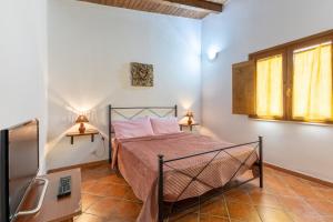 a bedroom with a bed and two lamps on a table at Lemalu con giardino in Menfi
