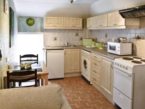 a kitchen with white appliances and a stove top oven at Gamekeepers Apt - Cv20 in Liskeard