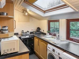 a kitchen with a sink and a stove at The Cottage in Whiting Bay