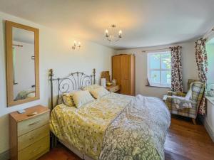 a bedroom with a bed and a dresser and a window at Fronisaf - Uk49775 in Llanfair Talhaiarn