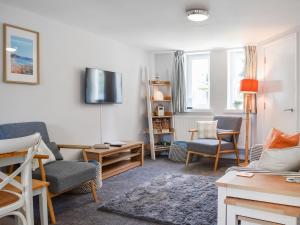 a living room with two chairs and a couch at Strandside Townhouse in Bude
