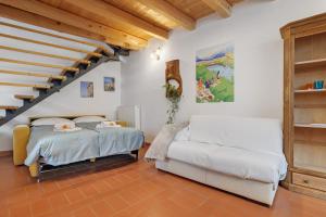 a bedroom with two beds and a staircase at Casa Sole in Ceniga