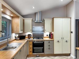 a kitchen with white cabinets and a stove top oven at Portland in Poole