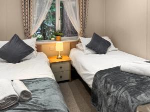 two beds in a room with a window at Portland in Poole