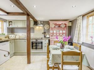a kitchen with a table with purple flowers on it at Duck Island Cottage in Ringwood +19 photos
