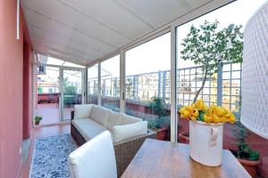 a living room with a couch and a table with yellow flowers at Attico Pavia vicino Policlinico in Rome