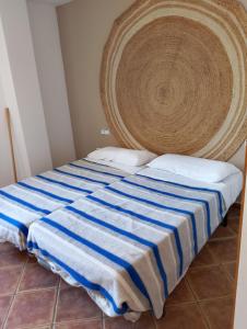 a bed with a blue and white striped blanket at Masllandrich Hostal Rural in Porqueres +9 photos
