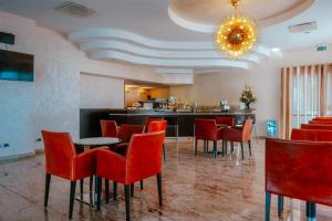 ein Restaurant mit roten Stühlen und einer Bar in der Unterkunft San Giorgio, Sure Hotel Collection by Best Western in Forlì