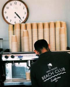 a man standing in front of a coffee machine with a clock at West Rocks Hotel in Eastbourne