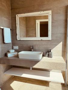a bathroom with a sink and a mirror at Villa La Mola Gozo Luxury Villa with Private Pool & Sunset Views in Għasri +25 photos