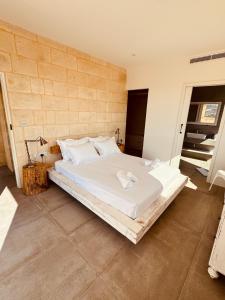 a bedroom with a large bed with white sheets and pillows at Villa La Mola Gozo Luxury Villa with Private Pool & Sunset Views in Għasri