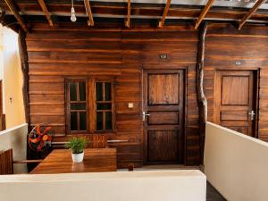 a room with wooden walls and wooden doors at Leaf Villa in Arugam Bay