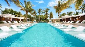 a pool with chairs and palm trees at a resort at Serenity at Coconut Bay All Inclusive - Couples Only in Vieux Fort