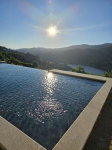 a swimming pool with a view of a lake at Quinta D'Joanes Douro in Resende