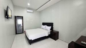 a bedroom with a bed and a dresser in it at Bwalk Hotel & Villa Malang in Sengkaling +34 photos