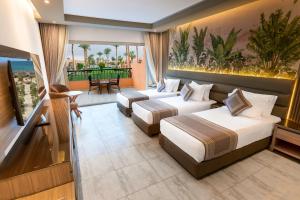 a hotel room with two beds and a balcony at Ali Baba Palace Resort - Families and Couples Only in Hurghada