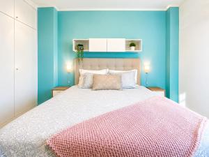 a bedroom with a large bed with blue walls at Lisbon Lux T1 Pool Gym Tennis AC - Pouso dos Anjos Apartment in Lisbon