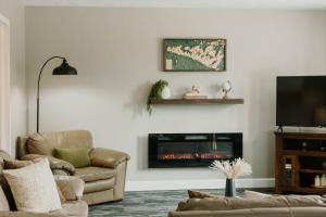 a living room with a couch and a fireplace at Manitoulin Inn in Mindemoya
