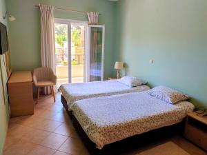 a bedroom with a bed and a sliding glass door at Athena Apartments in Vitalades