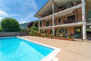 a house with a swimming pool in front of a house at The A-LINE Lake COMO view apt A with pool & garage in Tremezzo