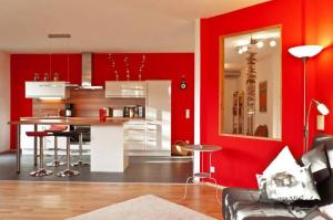 a living room with red walls and a kitchen at Paula in Bitz