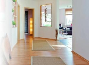 a living room with wooden floors and a hallway at Paula in Bitz