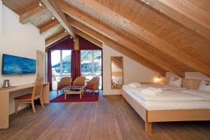 ein Schlafzimmer mit einem Bett und einem Schreibtisch in einem Zimmer in der Unterkunft Hotel Garni Passeier in Ischgl