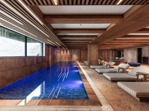 a pool in a hotel with lounge chairs and tables at Swissôtel Resort Kolasin in Kolašin