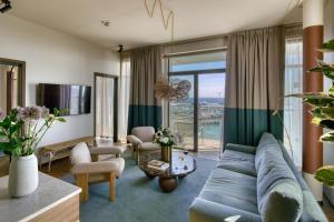 a living room with a blue couch and a large window at Willow, WorldHotels Crafted in Trelleborg