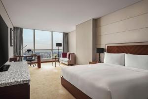 a hotel room with a large bed and a desk at InterContinental Hanoi Landmark72 by IHG in Hanoi