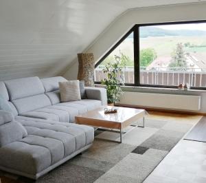 a living room with a couch and a table at Ferienwohnung Himmelblau in Strullendorf