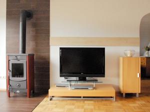 a living room with a tv and a stove at Ferienwohnung Himmelblau in Strullendorf +10 photos