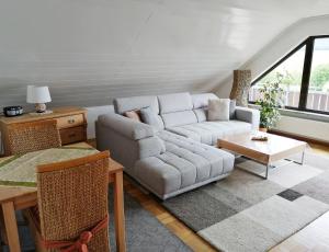 a living room with a couch and a table at Ferienwohnung Himmelblau in Strullendorf