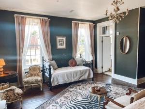 a room with a bed and a chair and windows at Historic Knox Hotel in Princeton