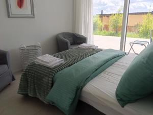a bedroom with a bed with a chair and a window at Hillfort suites in Lostorf