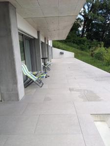 two lawn chairs sitting on a patio outside of a building at Hillfort suites in Lostorf