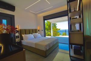 a bedroom with a bed and a balcony with a view at PNOẼ Luxury Apartments in Lourdata