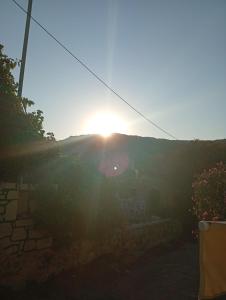 a sunset over a hill with the sun shining at Kimourioti Green House in Sitia