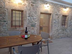 a dining room with a table and a bottle of wine at Kimourioti Green House in Sitia